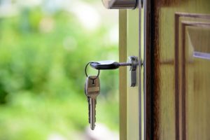 House key in door lock — symbolizing new homeownership or getting ready to buy a home.